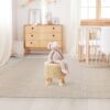Scandinavian children’s room: a basket for toys, a plush rabbit sitting on a chair, a cradle for a baby bed. Modern interior of a children’s bedroom. Rustic. Copy space. Hygge. Kindergarten interior