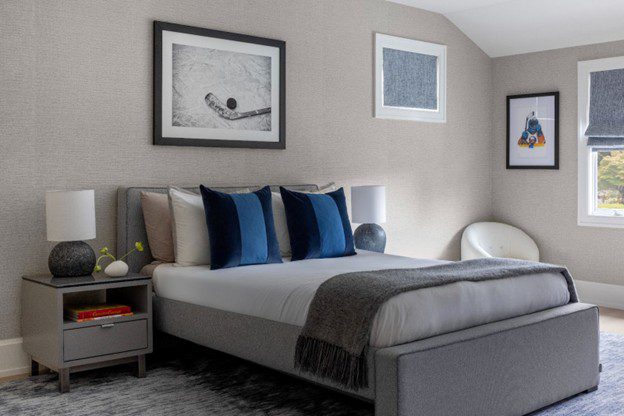 bedroom with a king size bed with blue pillows and brown walls