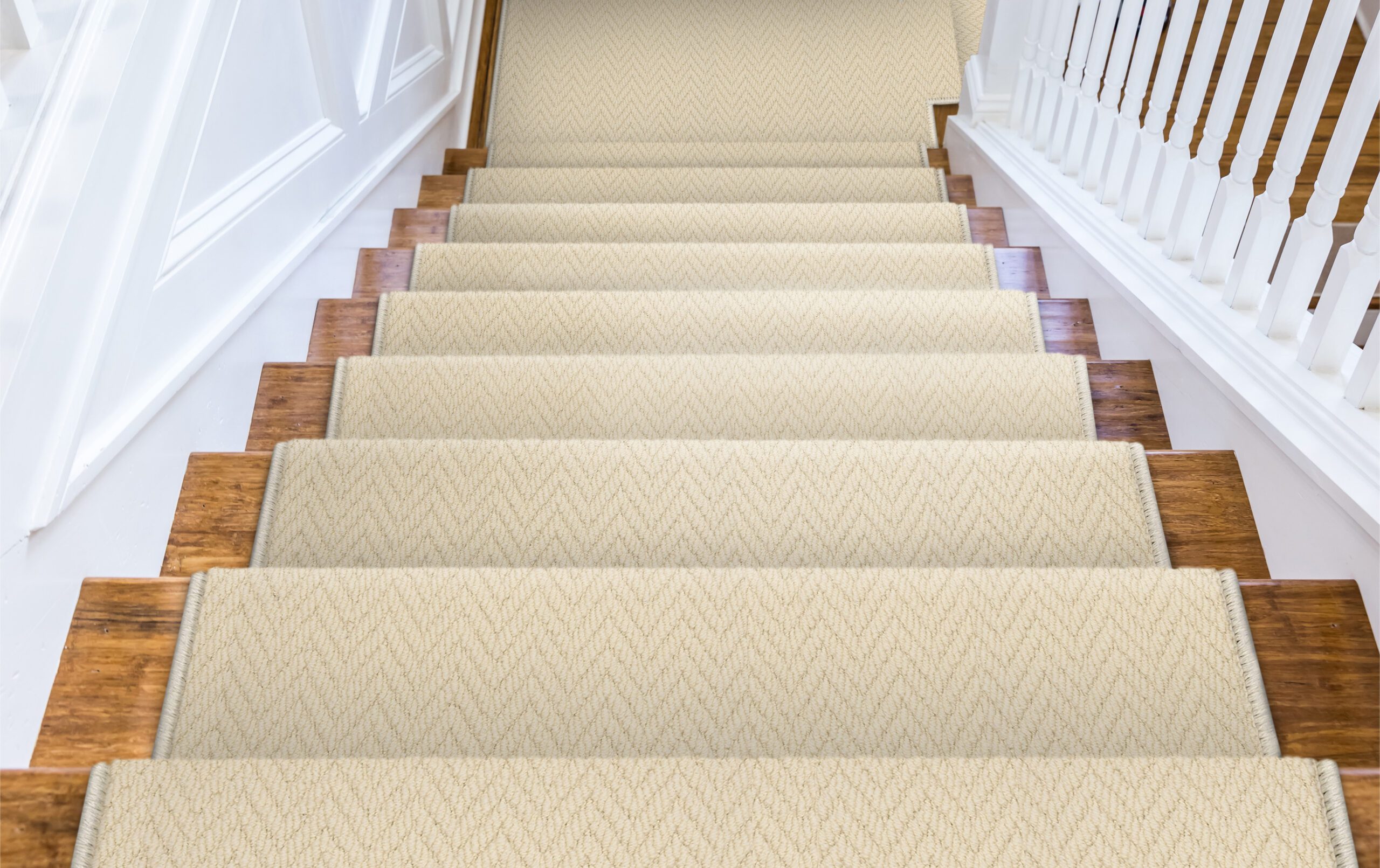 Wood stairs with carpet rug accents for grip with a white painted handrail in a new construction house Wood stairs with carpet rug accents for grip with a white painted handrail in a new construction house